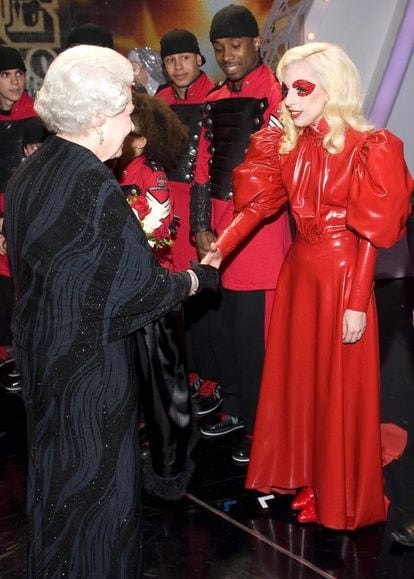 Lady Gaga saluda a la reina Isabel II tras su actuación en la gala ‘Royal Variety Show’, en 2009. Para la ocasión, la cantante eligió un vestido de látex rojo que emulaba a los vestidos de las cortesanas.