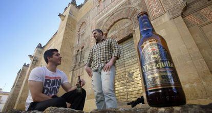 Dos jóvenes beben cerveza Mezquita junto al monumento cordobés.
