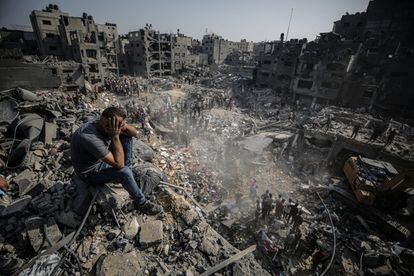 Un hombre sentado entre los escombros observa cómo los equipos de rescate palestinos trabajan tras un ataque de Israel el 1 de noviembre. 