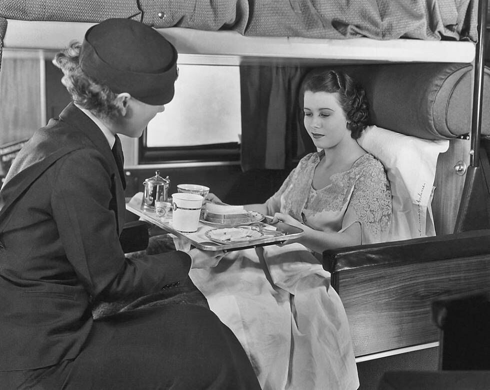 Una azafata sirve café y sandwiches a una pasajera de American Airlines en 1935.