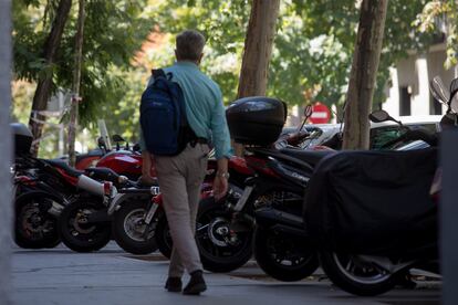 Un hombre camina por una acera llena de motos aparcadas, este jueves en Madrid.