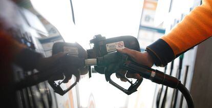 El empleado de una gasolinera echa diésel en un automóvil.
