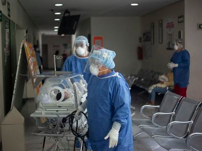 Trabajadores del área de la covid-19 trasladan a un bebé en un hospital en Ciudad de México.
