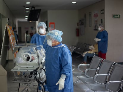 Trabajadores del área de la covid-19 trasladan a un bebé en un hospital en Ciudad de México.