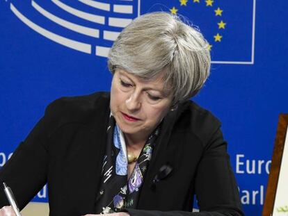 Theresa May firma en el libro de condolencias del Parlamento Europeo por el funeral de Helmut Khol. 