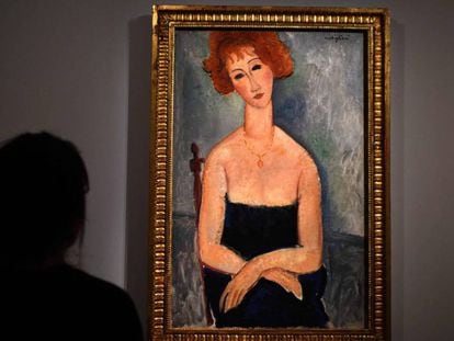 Una mujer mira 'Mujer pelirroja', de Amedeo Modigliani, en la muestra de Alicia Koplowitz en París.