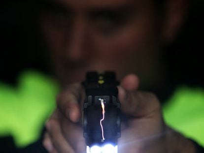 Un agente de la Policía Local de Moraleja de Enmedio (Madrid) empuña una pistola Taser.