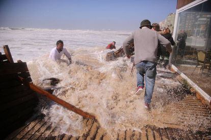 Los empleados del chiringuito El Potito intentan salvarlo del temporal con olas de mas de 6 metros en la playa de la Victoria , Cádiz.