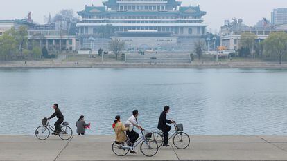 Varias personas pasean en bicicleta a orillas del río Taedong, en Pyongyang, Corea del Norte.