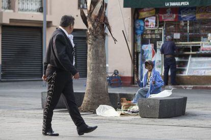 Un mariachi y una indigente, en la plaza de Garibaldi.