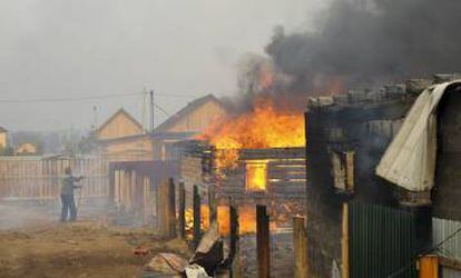 Un hombre trata de salvar su casa de las llamas en Siberia en 2015.