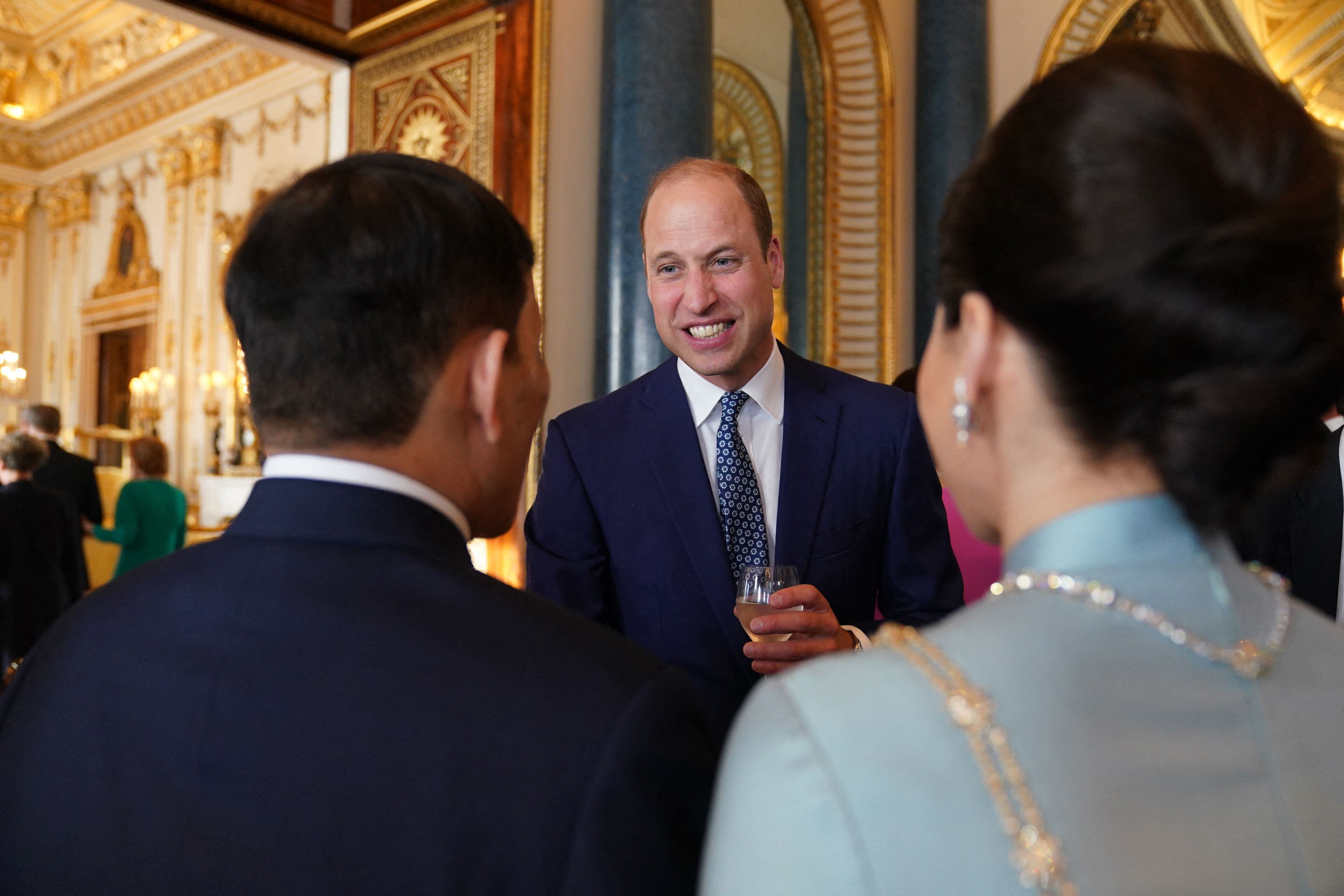El príncipe Guillermo, primogénito de Carlos III y heredero al trono británico, charla con la reina Suthida y el rey Vajiralongkorn de Tailandia durante la recepción.