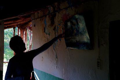 Una pobladora muestra un cuadro que quedó colgando en una vivienda de desplazados.