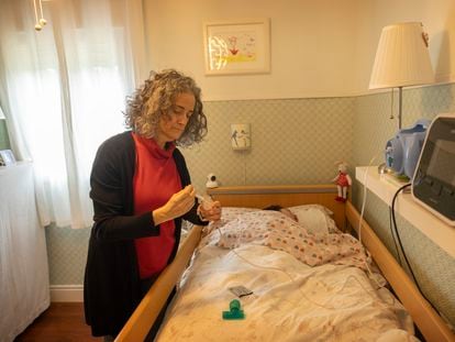 Inmaculada Márquez tiende a su hija, hospitalizada en régimen domiciliario y que precisa de cuidados paliativos pediátricos.