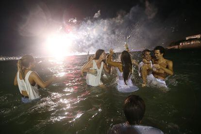 Varios jóvenes celebran la llegada del Año Nuevo en la playa en Río de Janeiro (Brasil).