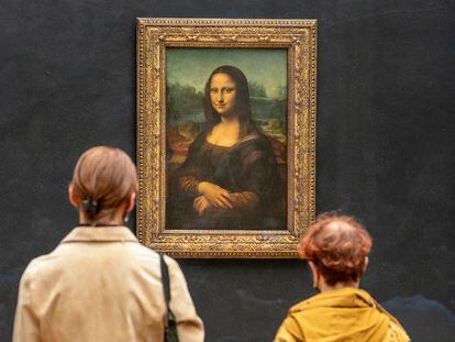 Dos personas observan la Mona Lisa de Leonardo Da Vinci en la galería del Louvre de París, Francia, en 2021.