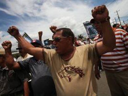Un grupo de personas protesta con pancartas frente a un grupo de policías este jueves 20 de junio de 2013, a las afueras de la sede del Instituto Nicaragüense de Seguridad Social (INSS) en Managua (Nicaragua).