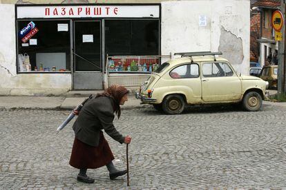 Una anciana camina pasa delante de un 600 en una calle de Foca, República Serbia de Bosnia.