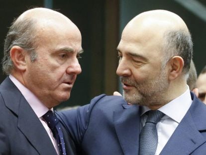 El ministro español de Economía, Luis de Guindos (i) conversa con el comisario europeo de Asuntos Económicos, Pierre Moscovici, durante una reunión de los responsables de Economía y Finanzas de la zona del euro en la sede del Consejo Europeo en Bruselas el 14 de enero de 2016.
