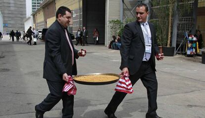 Dos treballadors transporten una paella a l'última edició d'Alimentaria.