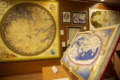 La exposición 'Los mapas y la primera vuelta al mundo. La expedición de Magallanes y Elcano' muestra mapas y cartas de navegación (originales y facsímiles) que parten desde los conceptos geográficos de los antiguos y llegan a la configuración del nuevo mapamundi que propició la circunnavegación. En primer término de la imagen se encuentra la reproducción facsímil del códice de la 'Geographia' de Ptolomeo, de 1470, conservado en la Biblioteca Apostólica Vaticana, donde destaca el océano Índico como un mar cerrado y la inexistencia de América.