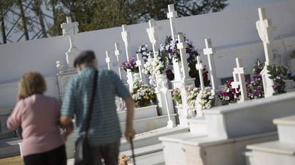 Pareja de ancianos visitando el cementerio de la localidad sevillana de Sanlúcar la Mayor (Sevilla).