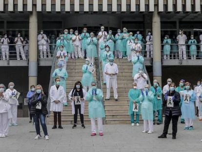 Sanitarios protegidos con mascarillas aplauden conmocionados tras el minuto de silencio en la entrada del Hospital Doctor Peset por la técnica de enfermería fallecida por coronavirus, en Valencia.
 
 