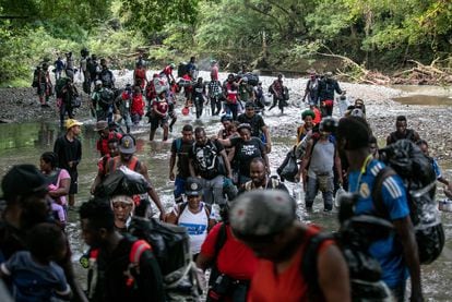 Un grupo de migrantes cruza un río en la selva del Darién, cerca de Acandí, en Colombia, el 7 de octubre de 2021.