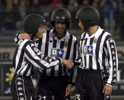 Montero (I), Zidane y Iuliano (D) bromean llevando cascos de moto antes de un partido ante la Lazio