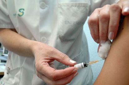Una enfermera inyecta una vacuna.