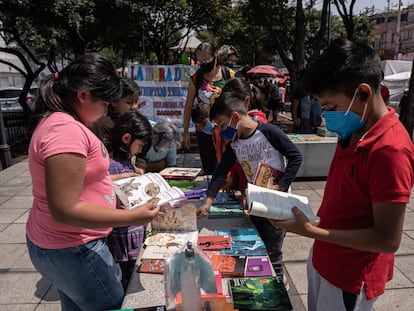 Varios niños revisan la colección '21 para el 21' en un tianguis de Coyoacán, el 2 de octubre.