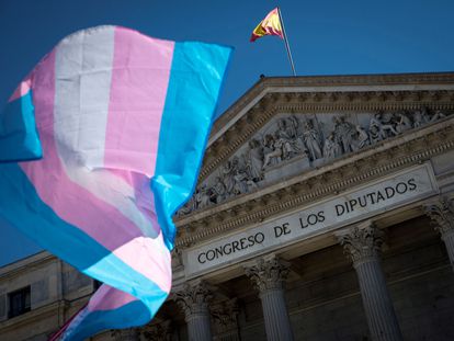Una bandera trans ondea ante el Congreso de los Diputados, en junio de 2022.