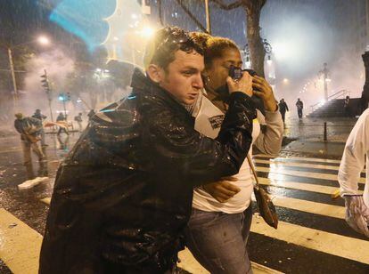 Una mujer es asistida tras inhalar gases lacrimógenos lanzados por la policía durante la protesta tras la manifestación en apoyo a los profesores en Río de Janeiro, 7 de octubre de 2013.