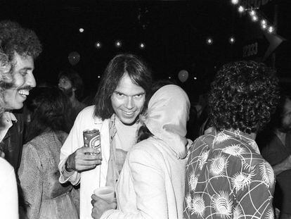 Neil Young, con una lata de cerveza en la mano, hablando con la cantante Nicolette Larson en la presentación de la película y disco 'Rust never sleeps' (donde se incluye 'Hey hey, my my (into the black)'. La fiesta fue en agosto de 1979 en Los Ángeles.