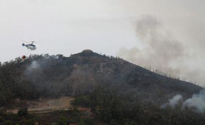 Un helicoptero durante las funciones de extinci&oacute;n del incendio forestal en Ceuta este lunes.