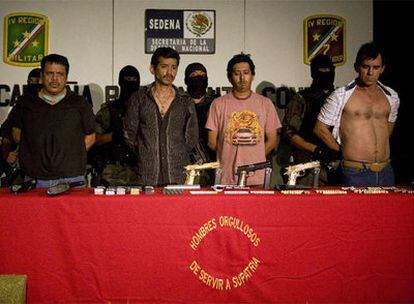 Cuatro de los sicarios detenidos en México con las armas incautadas por el Ejército.