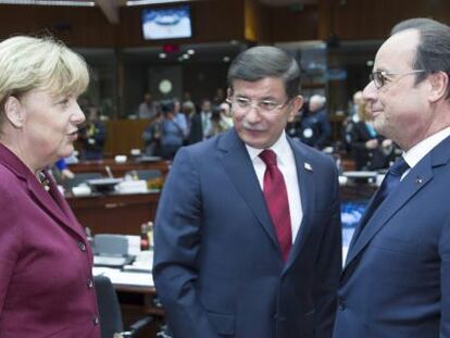 La canciller alemana, Angela Merkel, charla con el primer ministro turco, Ahmet Davutoglu, y el presidente franc&eacute;s, Francois Hollande, en la cumbre extraordinaria sobre la inmigraci&oacute;n.