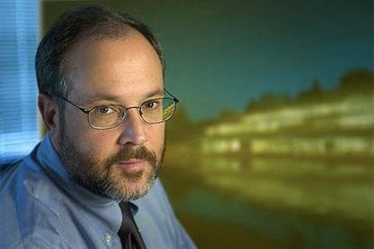 Gerald M. Rubin, director de Janelia, posa con una imagen del centro de investigación a la derecha.