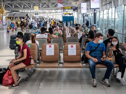 Viajeros llevando máscaras en el aeropuerto de Babkok y respetando la distancia de seguridad que indican los carteles, el 25 de marzo del 2020.