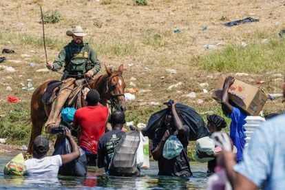 Un agente fronterizo amenaza con una soga a un grupo de migrantes en el río Grande, entre Texas y México, este 19 de septiembre.