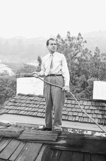 Nixon riega el tejado de su casa en Los Ángeles como medida de prevención durante un incendio en 1961.