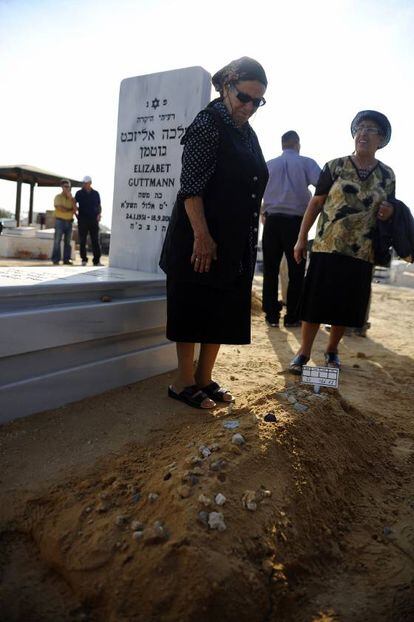 Dos mujeres israelíes junto a la tumba de un hombre muerto por un cohete arrojado desde Gaza.