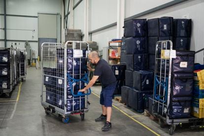 Manuel Vázquez, uno de los cuatro preparadores de pedidos 'online' que trabaja en el almacén de Terrassa, mueve un carro con cinco cajas preparadas para cargarlas en el vehículo de Correos.