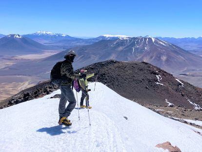 Jay Storz y Mario Pérez Mamani bajan desde la cumbre del Cerro Vicuñas,que fue investigado sin encontrar ratones.