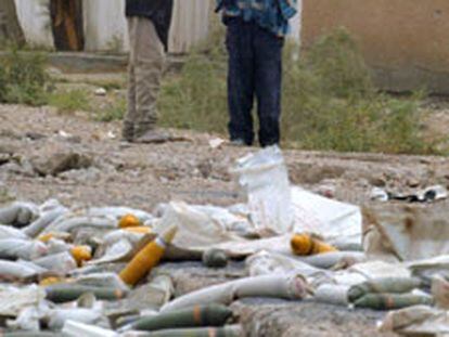 Unos niños, ayer en Basora, junto a unos proyectiles sin explotar.
