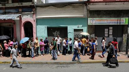 Vecinos de Caracas, Venezuela, haciendo cola para poder comprar alimentos en un supermercado.