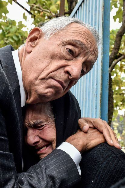 El presidente luso, Marcelo Rebelo de Sousa, abraza a una mujer mientras llora, durante una visita a los municipios del centro del país afectados por los incendios forestales de la semana pasada, en Santa Comba, Vouzela (Portugal).