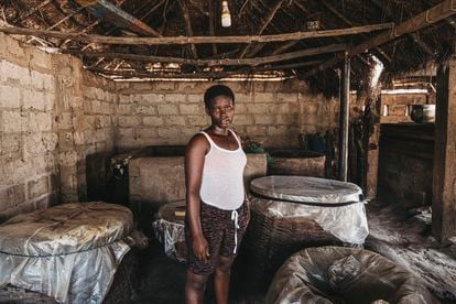 Nana de, 14 años, junto a las tinajas de ahumar pescado. "La obligación es trabajar, ya que si no, no podemos comer en casa", dice Otuku, su madre.
