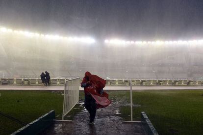 Un fotògraf es protegeix de la pluja al Monumental.