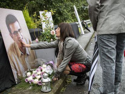 La viuda de Eduardo Puelles deposita flores en el lugar donde fue asesinado su marido.